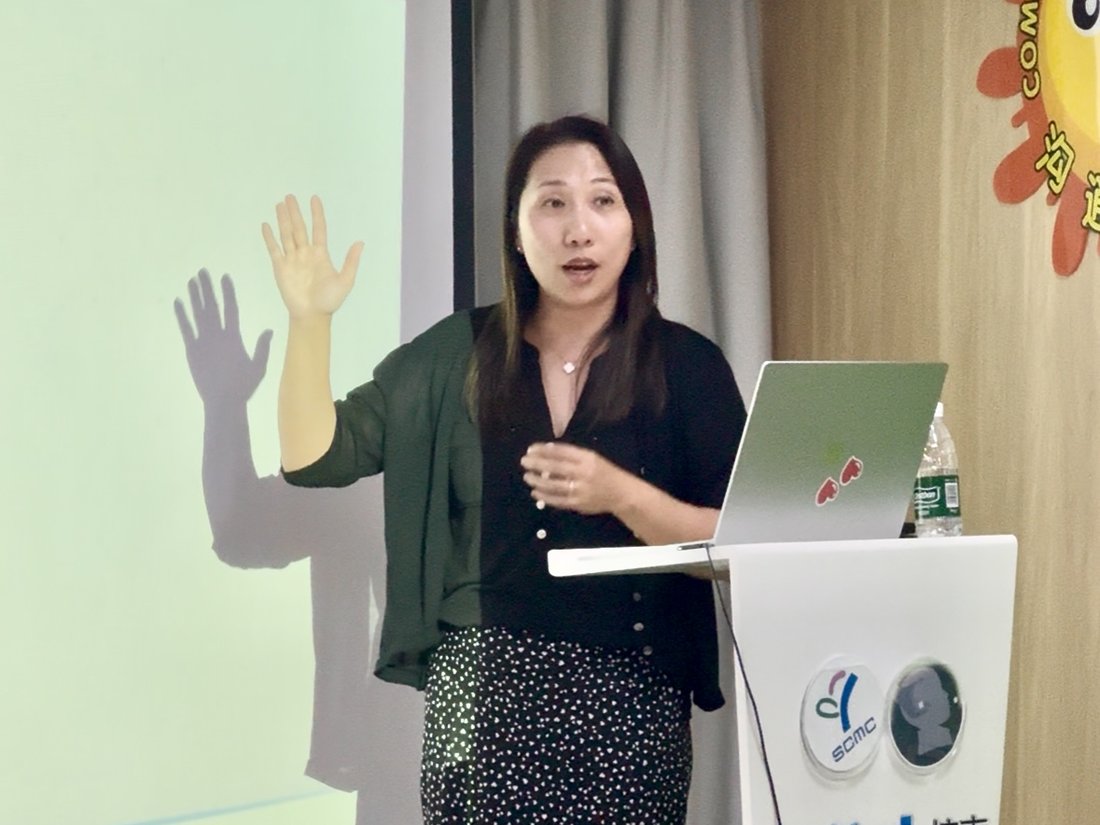Linda Chow presenting at a Bethel workshop in Shanghai, speaking from the lectern beside her slides